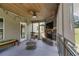 Inviting screened porch features a stone fireplace, wood ceiling, string lights, and serene outdoor views at 127 Grayson Myers Dr, Villa Rica, GA 30180