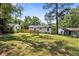 Expansive grassy backyard showcasing the rear of the home, wooden deck, and mature trees at 4134 Burgess Dr, Decatur, GA 30035
