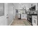 Open-concept kitchen featuring stainless steel appliances, white cabinetry, and a view to the living area at 4134 Burgess Dr, Decatur, GA 30035