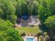 Overhead shot of a private pool, sand volleyball court, playground, and pathways amidst beautiful, mature trees at 4680 Brighton Lake Dr, Cumming, GA 30040