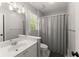 Neutral bathroom featuring a white vanity, shower-tub with gray curtain, and window with natural light at 4680 Brighton Lake Dr, Cumming, GA 30040
