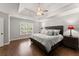 Main bedroom featuring tray ceilings, hardwood floors, and neutral wall color at 4680 Brighton Lake Dr, Cumming, GA 30040