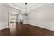 Elegant dining room featuring hardwood floors, a modern chandelier, and classic wainscoting for sophisticated appeal at 4680 Brighton Lake Dr, Cumming, GA 30040