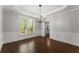 Elegant dining room with wainscoting, hardwood floors, modern chandelier, and natural light from large windows at 4680 Brighton Lake Dr, Cumming, GA 30040