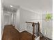 Hallway showcasing hardwood floors, white trim, and an open view of the foyer with a staircase at 4680 Brighton Lake Dr, Cumming, GA 30040
