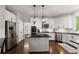 Spacious kitchen with stainless steel appliances, a central island, white cabinets, and views into other living areas at 4680 Brighton Lake Dr, Cumming, GA 30040