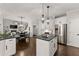 Open concept kitchen with a central island and stainless steel appliances seamlessly connected to the dining and living area at 4680 Brighton Lake Dr, Cumming, GA 30040