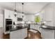 Bright kitchen featuring white cabinets, subway tile backsplash, dark countertops, and an island with wood paneling at 4680 Brighton Lake Dr, Cumming, GA 30040