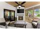 Inviting sunroom with a cozy fireplace, TV, and French doors to backyard at 4680 Brighton Lake Dr, Cumming, GA 30040