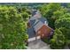 Aerial view of the back side of the brick home, featuring a two-car garage and private backyard at 5260 Harbury Ln, Suwanee, GA 30024