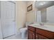 Bright bathroom featuring a white door, toilet, sink with vanity, and framed wall art at 5260 Harbury Ln, Suwanee, GA 30024