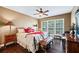 Cozy bedroom with a ceiling fan, plush bedding, and a window letting in natural light at 5260 Harbury Ln, Suwanee, GA 30024