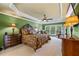 Well-lit bedroom features a ceiling fan, a large bed and window views at 5260 Harbury Ln, Suwanee, GA 30024
