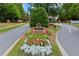 Welcoming Edinburgh community entrance featuring beautiful landscaping and signage surrounded by lush greenery and mature trees at 5260 Harbury Ln, Suwanee, GA 30024