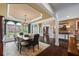 Elegant dining room featuring a large table, chandelier, and expansive windows showcasing the lush landscaping at 5260 Harbury Ln, Suwanee, GA 30024