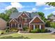 Beautiful two-story brick home with a well-maintained lawn, landscaping, and a welcoming facade at 5260 Harbury Ln, Suwanee, GA 30024