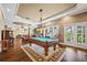 Spacious game room with a pool table, hardwood floors, and large windows with beautiful outdoor views at 5260 Harbury Ln, Suwanee, GA 30024