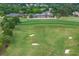 Aerial view of a pristine golf course surrounded by lush greenery, showcasing its well-maintained fairways and landscape at 5260 Harbury Ln, Suwanee, GA 30024