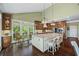 Spacious kitchen featuring an island, stainless steel appliances, and large windows with views of the lush backyard at 5260 Harbury Ln, Suwanee, GA 30024