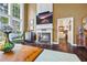 Bright living room with a fireplace, TV, large windows, and hardwood floors at 5260 Harbury Ln, Suwanee, GA 30024