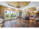 Open living room with large windows, hardwood floors, and a pool table in the background at 5260 Harbury Ln, Suwanee, GA 30024