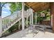 Outdoor seating area under deck features a wrought iron table and chairs for entertaining at 5260 Harbury Ln, Suwanee, GA 30024