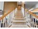 Carpeted staircase with white spindles and wooden handrail leading to upper level at 5260 Harbury Ln, Suwanee, GA 30024