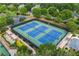 Aerial view of well-maintained tennis courts perfect for recreational and competitive play, surrounded by landscaped grounds at 5260 Harbury Ln, Suwanee, GA 30024