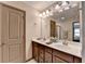This bathroom offers double sinks, cabinet storage, and a large mirror with vanity lighting, promoting a bright space at 5870 Shiloh Woods Dr, Cumming, GA 30040