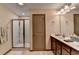 This bathroom offers double sinks, cabinet storage, a glass shower, and a large mirror, promoting a bright space at 5870 Shiloh Woods Dr, Cumming, GA 30040