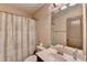 This bathroom features a toilet, vanity, and shower/bath combo with a patterned curtain, promoting relaxation at 5870 Shiloh Woods Dr, Cumming, GA 30040