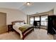 Spacious bedroom with vaulted ceiling, large windows, and a comfortable bed with stylish furnishings at 5870 Shiloh Woods Dr, Cumming, GA 30040