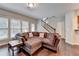 Cozy living room featuring plush sectional sofa, hardwood floors, and staircase access to upper level at 5870 Shiloh Woods Dr, Cumming, GA 30040
