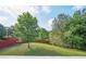 Beautiful, expansive backyard with mature landscaping, lush green grass, and a privacy fence at 7169 Sweet Gum Ct, Lithonia, GA 30058