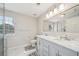 Well-lit bathroom featuring double sinks, marble countertops, and a glass-enclosed shower with modern fixtures at 7169 Sweet Gum Ct, Lithonia, GA 30058