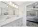 Well-lit bathroom featuring double sinks, marble countertops, and a glass-enclosed shower with modern fixtures at 7169 Sweet Gum Ct, Lithonia, GA 30058