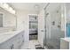 Well-lit bathroom featuring double sinks, marble countertops, and a glass-enclosed shower with modern fixtures at 7169 Sweet Gum Ct, Lithonia, GA 30058