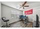 Well-lit bedroom featuring hardwood floors, a ceiling fan, and a convenient workspace at 7169 Sweet Gum Ct, Lithonia, GA 30058