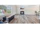 Living room features a fireplace, luxury vinyl floors, and window bringing in natural light at 7169 Sweet Gum Ct, Lithonia, GA 30058