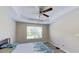 Bright main bedroom with a tray ceiling, ceiling fan, and large window offering great natural light at 7169 Sweet Gum Ct, Lithonia, GA 30058