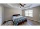 Bright main bedroom with a tray ceiling, ceiling fan, and large window offering great natural light at 7169 Sweet Gum Ct, Lithonia, GA 30058