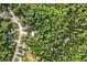 Areal photo of a neighborhood with wooded areas, homes, swimming pools, and winding roads at 1020 Travitine Trl, Loganville, GA 30052