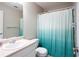 Clean bathroom with a turquoise shower curtain, a white sink, and a toilet at 1020 Travitine Trl, Loganville, GA 30052