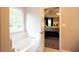 Bright bathroom featuring a soaking tub and a view into the bedroom at 1020 Travitine Trl, Loganville, GA 30052