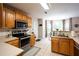 Bright kitchen featuring stainless steel appliances, wood cabinets, and tile flooring, with a view to the breakfast nook at 1020 Travitine Trl, Loganville, GA 30052