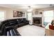 Spacious living room features a fireplace with stone surround, large windows, and a comfortable sectional sofa at 1020 Travitine Trl, Loganville, GA 30052