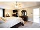 Spacious main bedroom featuring a ceiling fan, TV, and elegant dark wood furniture set at 1020 Travitine Trl, Loganville, GA 30052