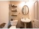 Stylish powder room featuring floating shelves, a pedestal sink, and neutral tones at 1020 Travitine Trl, Loganville, GA 30052