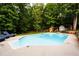 Inviting in-ground swimming pool with lounge chairs and a play set, set amongst mature trees at 1020 Travitine Trl, Loganville, GA 30052