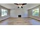Large living area with a ceiling fan, fireplace, and ample windows that bring in natural light at 10961 Big Sky Dr, Hampton, GA 30228